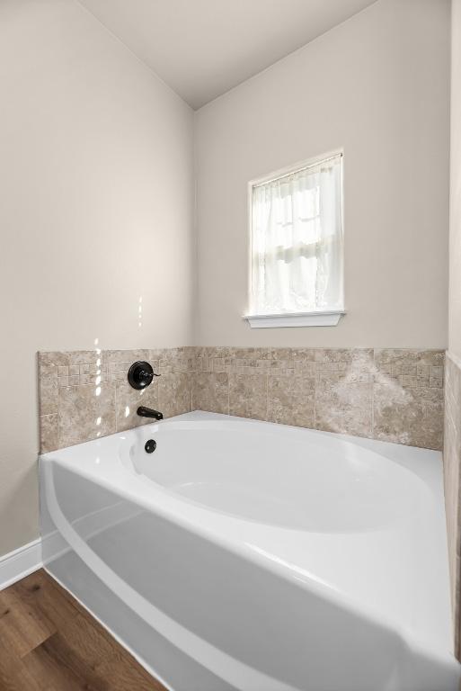 125 Brahman Ct, Bastrop, TX 78602 - bathroom featuring a garden tub, wood finished floors, and baseboards
