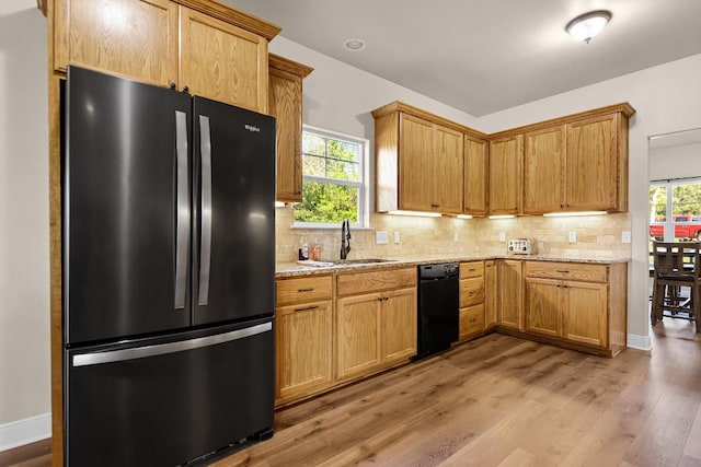 125 Brahman Ct, Bastrop, TX 78602 - kitchen featuring freestanding refrigerator, dishwasher, a sink, decorative backsplash, and wood finished floors