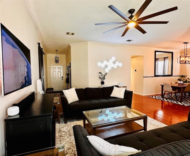 16903 Isle Of Man Rd, Pflugerville, TX 78660 - living room featuring a ceiling fan, ornamental molding, wood finished floors, a chandelier, and baseboards