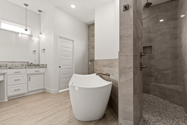 112 Vista De Luna Ln, Belton, TX 76513 - bathroom featuring a freestanding tub, vanity, a walk in shower, wood finished floors, and recessed lighting