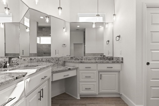 112 Vista De Luna Ln, Belton, TX 76513 - bathroom featuring two vanities, a tile shower, and wood tiled floors