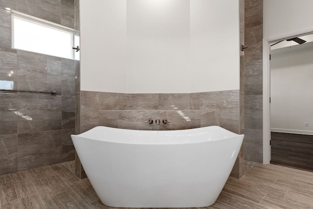 112 Vista De Luna Ln, Belton, TX 76513 - bathroom featuring tile walls, a soaking tub, wainscoting, and a walk in shower