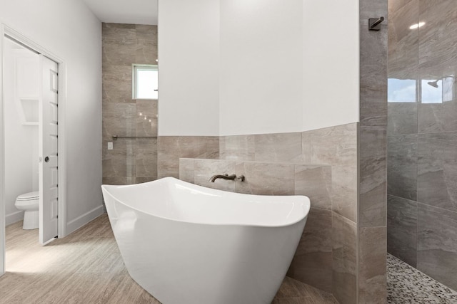 112 Vista De Luna Ln, Belton, TX 76513 - full bath featuring tile walls, a freestanding tub, a walk in shower, wood finished floors, and wainscoting
