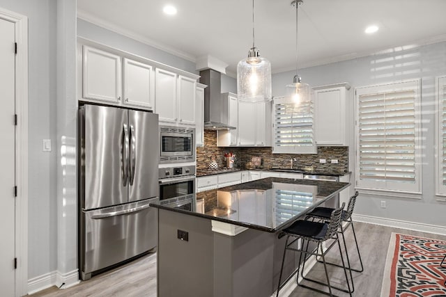 1013 Highknoll Ln, Georgetown, TX 78628 - kitchen featuring stainless steel appliances, wall chimney exhaust hood, a center island, light wood-style flooring, and crown molding
