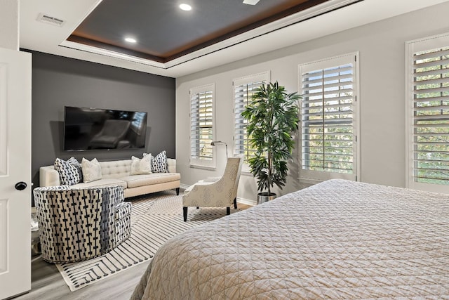 1013 Highknoll Ln, Georgetown, TX 78628 - bedroom with wood finished floors, multiple windows, a tray ceiling, and recessed lighting