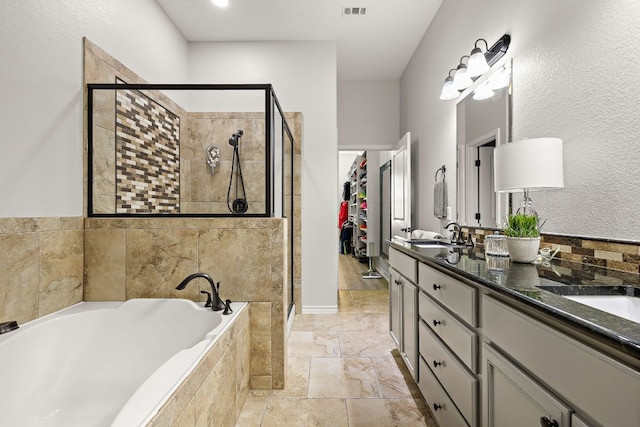 1013 Highknoll Ln, Georgetown, TX 78628 - bathroom featuring a shower stall, a bath, double vanity, and a spacious closet