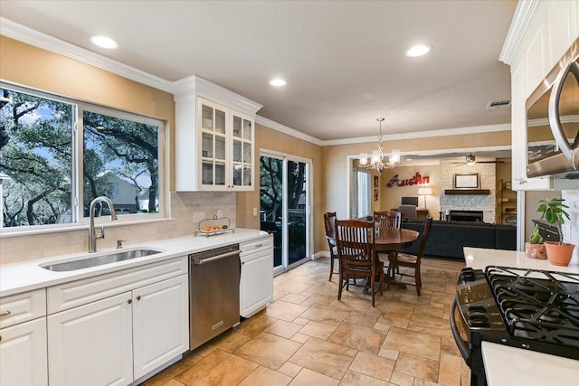8007 Davis Mountain Cv, Austin, TX 78726 - kitchen with appliances with stainless steel finishes, tasteful backsplash, a stone fireplace, stone tile flooring, and light countertops