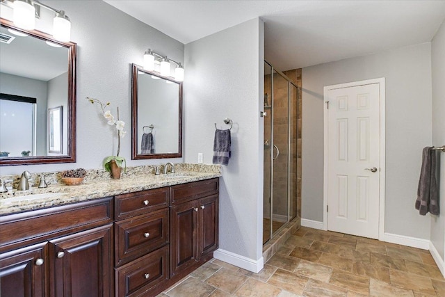 8007 Davis Mountain Cv, Austin, TX 78726 - bathroom featuring double vanity, a shower stall, and stone finish flooring