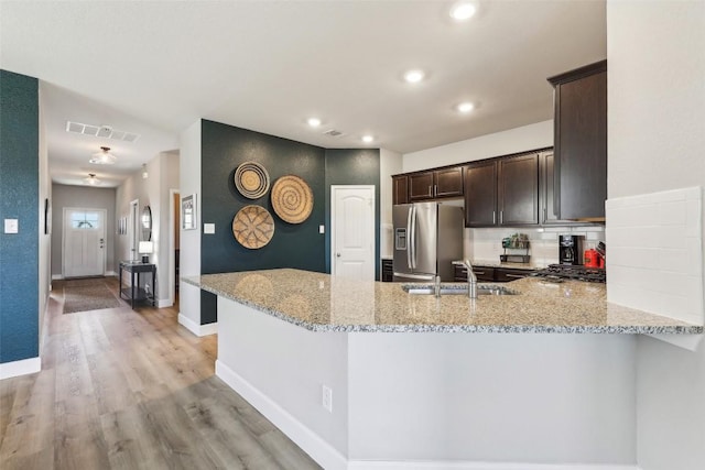 353 Cherry Laurel Ln, Kyle, TX 78640 - kitchen featuring stainless steel fridge with ice dispenser, a sink, dark brown cabinets, light stone counters, and light wood-style flooring