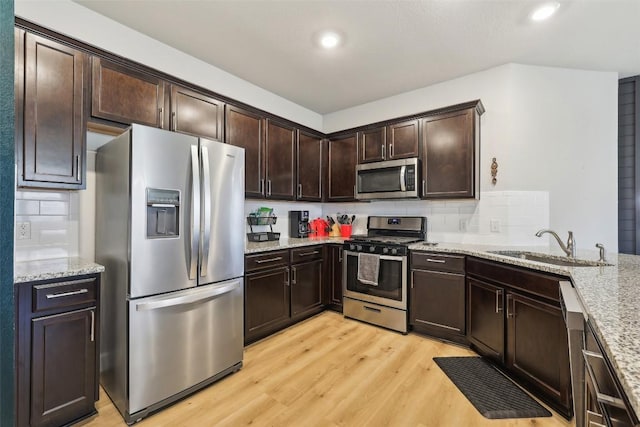 353 Cherry Laurel Ln, Kyle, TX 78640 - kitchen with appliances with stainless steel finishes, a sink, tasteful backsplash, dark brown cabinetry, and recessed lighting