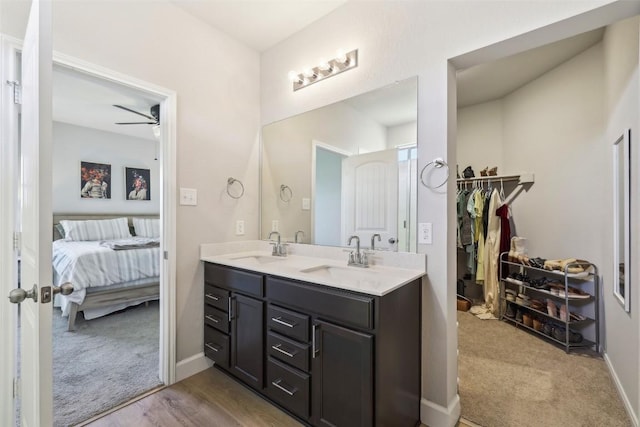 353 Cherry Laurel Ln, Kyle, TX 78640 - ensuite bathroom featuring ceiling fan, double vanity, a walk in closet, and baseboards