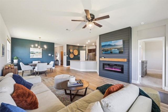 353 Cherry Laurel Ln, Kyle, TX 78640 - living area featuring a chandelier, a ceiling fan, light wood-type flooring, and baseboards