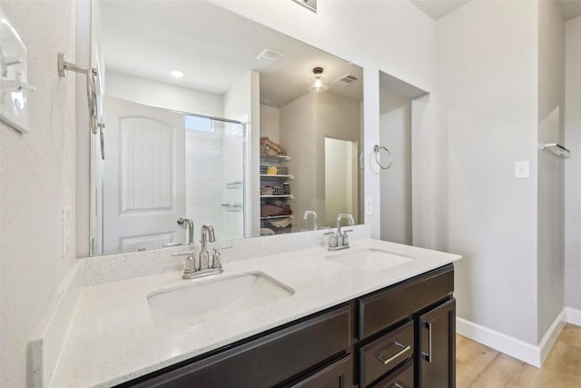 353 Cherry Laurel Ln, Kyle, TX 78640 - full bathroom with double vanity, baseboards, wood finished floors, and an enclosed shower