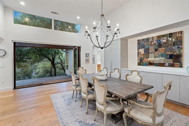 7 Rocky River Cv, West Lake Hills, TX 78746 - dining area featuring a towering ceiling, a notable chandelier, recessed lighting, visible vents, and light wood finished floors