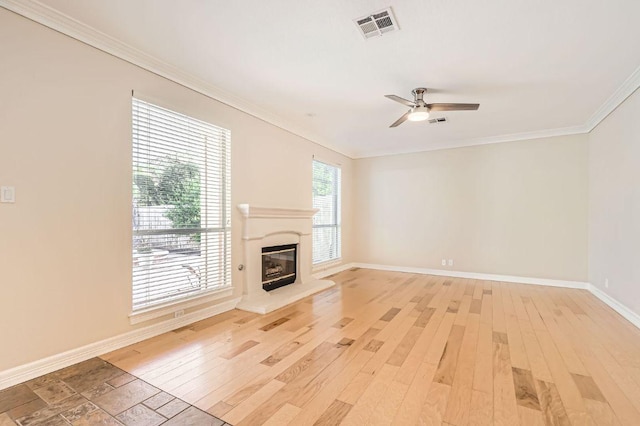 8404 Cahill Dr, Austin, TX 78729 - unfurnished living room featuring crown molding, baseboards, a ceiling fan, light wood-type flooring, and a glass covered fireplace