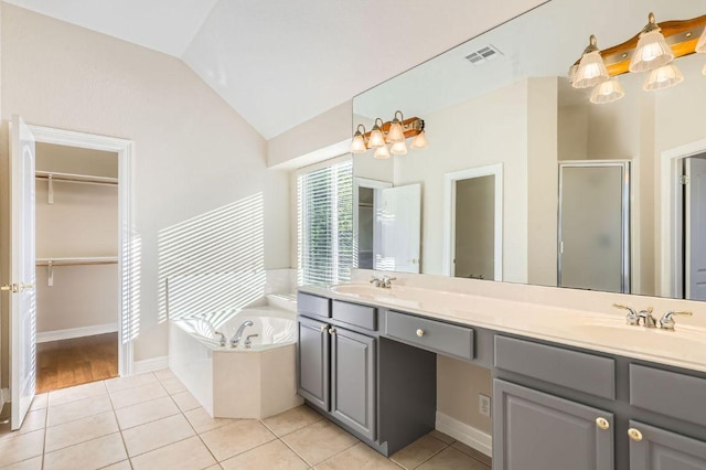 8404 Cahill Dr, Austin, TX 78729 - full bath with a shower stall, double vanity, a garden tub, vaulted ceiling, and a walk in closet