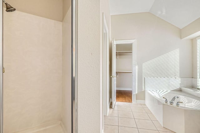 8404 Cahill Dr, Austin, TX 78729 - bathroom featuring a shower stall, tile patterned floors, a garden tub, a walk in closet, and lofted ceiling