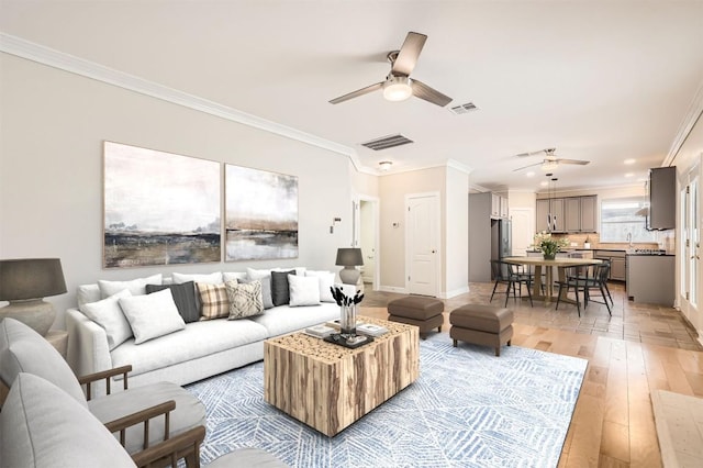 8404 Cahill Dr, Austin, TX 78729 - living room featuring a ceiling fan, ornamental molding, light wood finished floors, and baseboards
