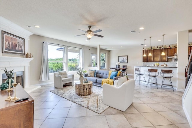 4829 Pyrenees Pass, Austin, TX 78738 - living room featuring recessed lighting, a ceiling fan, light tile patterned floors, a fireplace with raised hearth, and a textured ceiling