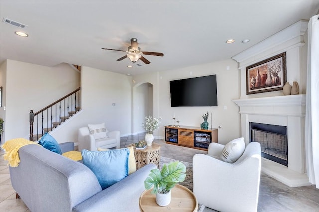 4829 Pyrenees Pass, Austin, TX 78738 - living room featuring a fireplace with raised hearth, recessed lighting, stairs, arched walkways, and ceiling fan