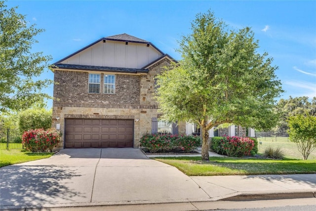 4829 Pyrenees Pass, Austin, TX 78738 - view of front of property with concrete driveway, stone siding, an attached garage, board and batten siding, and brick siding