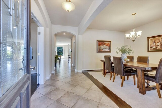 4829 Pyrenees Pass, Austin, TX 78738 - dining area with arched walkways, light tile patterned floors, and a chandelier