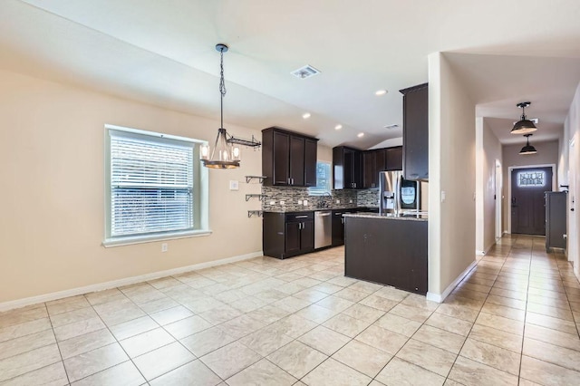 kitchen featuring tasteful backsplash, appliances with stainless steel finishes, vaulted ceiling, and plenty of natural light