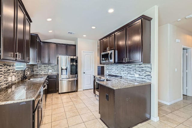 kitchen with dark brown cabinetry, visible vents, dark stone counters, appliances with stainless steel finishes, and a sink