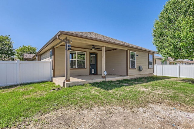 back of house with a fenced backyard, ceiling fan, a patio, and a lawn