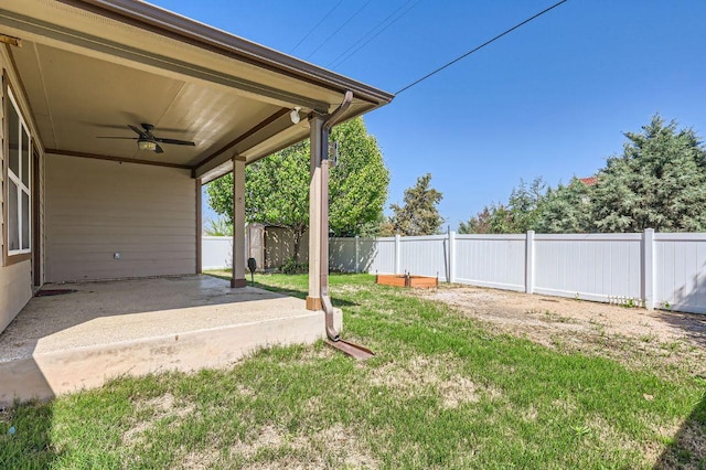 view of yard with an outbuilding, a fenced backyard, a ceiling fan, a patio, and a storage unit