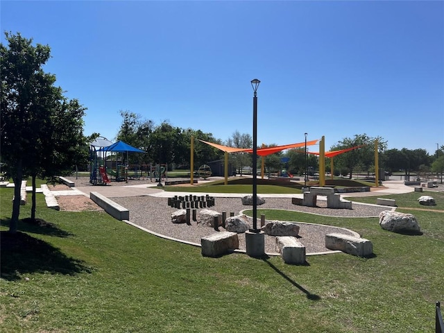 view of property's community with playground community and a lawn