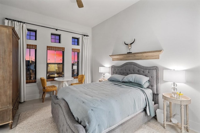 bedroom with a ceiling fan, baseboards, and wood finished floors