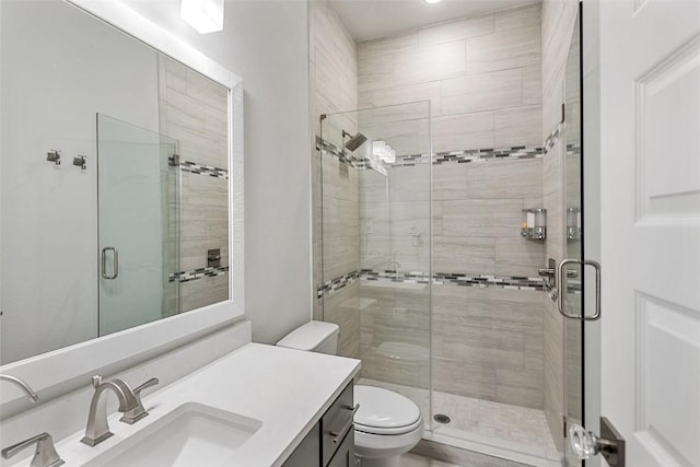 bathroom featuring vanity, a stall shower, and toilet
