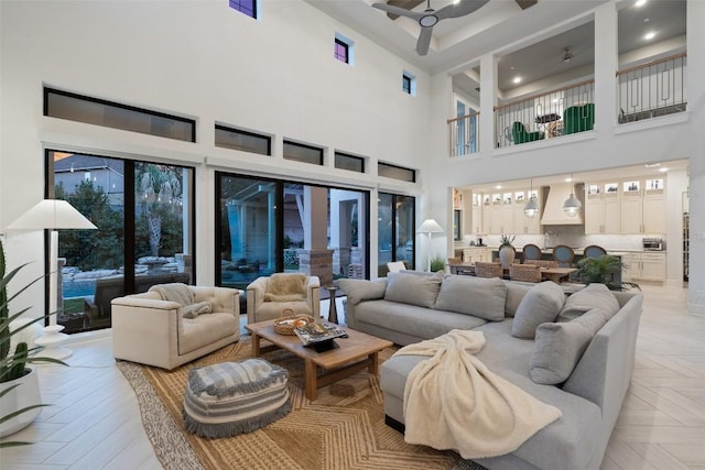 living area with a high ceiling and a ceiling fan