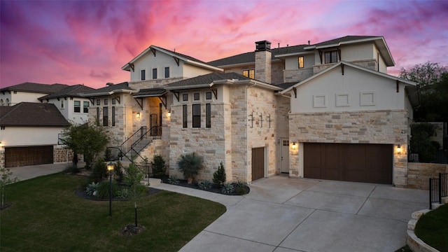 view of front facade with a front lawn, concrete driveway, an attached garage, stone siding, and stucco siding