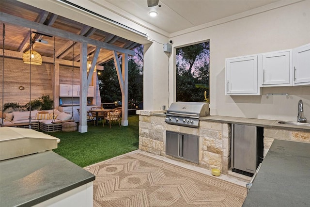 view of patio / terrace featuring an outdoor living space, a sink, exterior kitchen, and grilling area