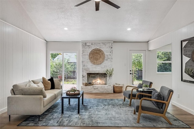 12305 Rustic Manor Ct, Austin, TX 78750 - living room featuring vaulted ceiling, wood finished floors, a textured ceiling, ceiling fan, and a fireplace