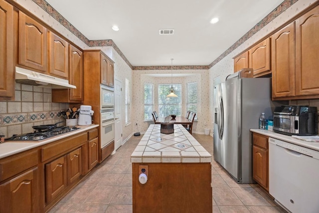 100 Egret Cv, Georgetown, TX 78633 - kitchen featuring stainless steel appliances, under cabinet range hood, visible vents, and wallpapered walls