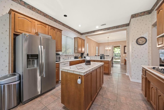 100 Egret Cv, Georgetown, TX 78633 - kitchen featuring a center island, a chandelier, a peninsula, wallpapered walls, and stainless steel appliances