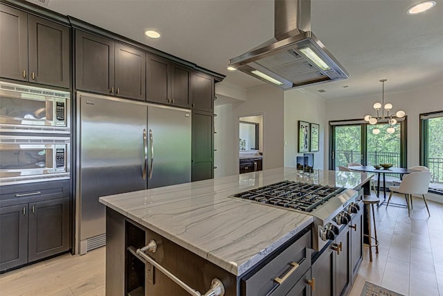 3502 Native Dancer Cv, Austin, TX 78746 - kitchen featuring built in appliances, exhaust hood, light stone counters, a chandelier, and dark brown cabinetry