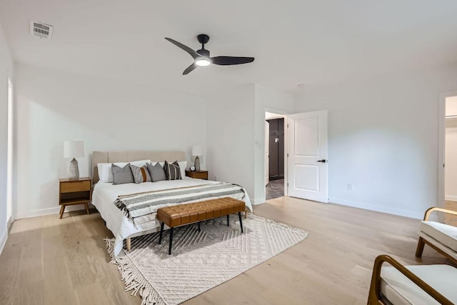 bedroom with light wood-style floors, ceiling fan, baseboards, and visible vents