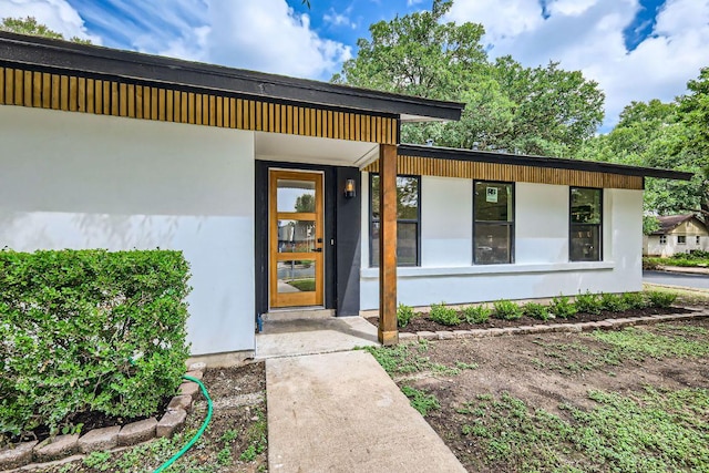 entrance to property featuring stucco siding