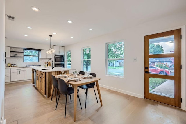 dining space with recessed lighting, light wood finished floors, visible vents, and baseboards