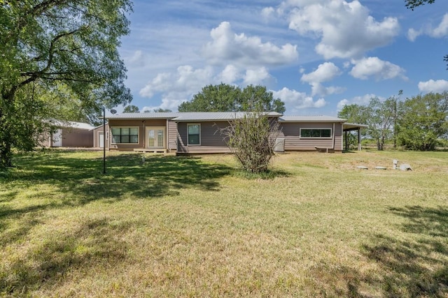 1229 State Highway 304, Gonzales, TX 78629 - back of property featuring a lawn and a metal roof