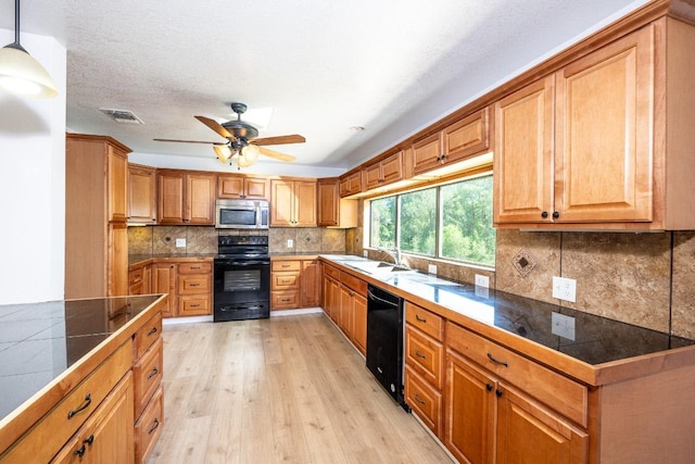 1229 State Highway 304, Gonzales, TX 78629 - kitchen featuring black appliances, a ceiling fan, light wood-type flooring, backsplash, and brown cabinets