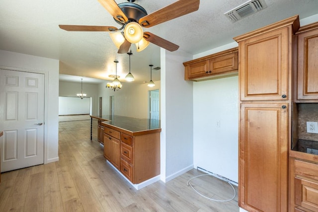1229 State Highway 304, Gonzales, TX 78629 - kitchen featuring a chandelier, brown cabinets, ceiling fan, light wood finished floors, and tile counters