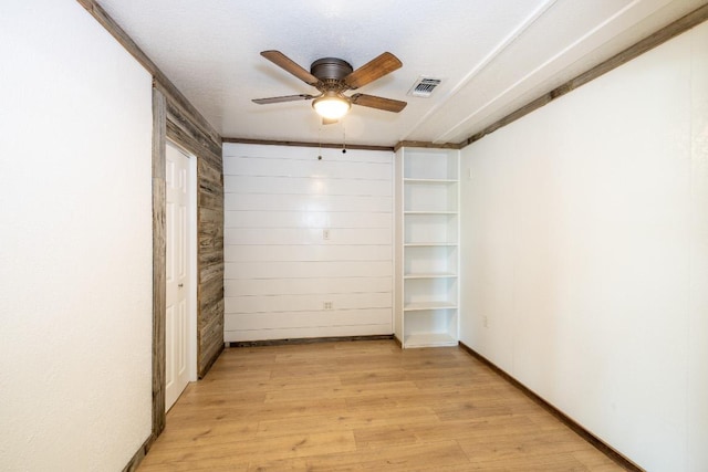 1229 State Highway 304, Gonzales, TX 78629 - empty room with light wood finished floors, ceiling fan, and wooden walls