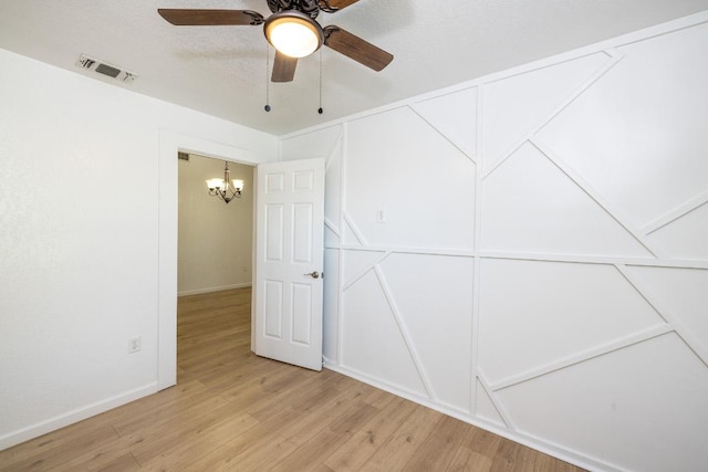 1229 State Highway 304, Gonzales, TX 78629 - spare room with a chandelier, light wood finished floors, and a ceiling fan