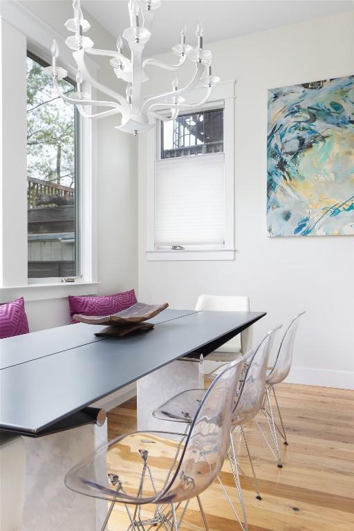 606 E 42nd St, Austin, TX 78751 - dining area featuring a chandelier, plenty of natural light, wood finished floors, and baseboards