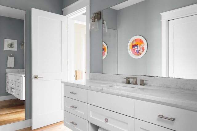 606 E 42nd St, Austin, TX 78751 - bathroom with vanity, wood finished floors, and baseboards